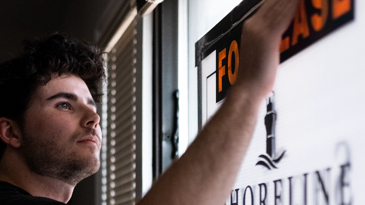 An image of Toronto rental agent Marco Pedri putting up a For Lease sign on a rental property in Toronto, Ontario.
