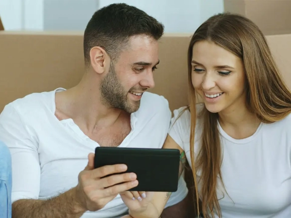 An image of a tenant couple searching online for Toronto rentals on their phone reading the description of the toronto rental listings.