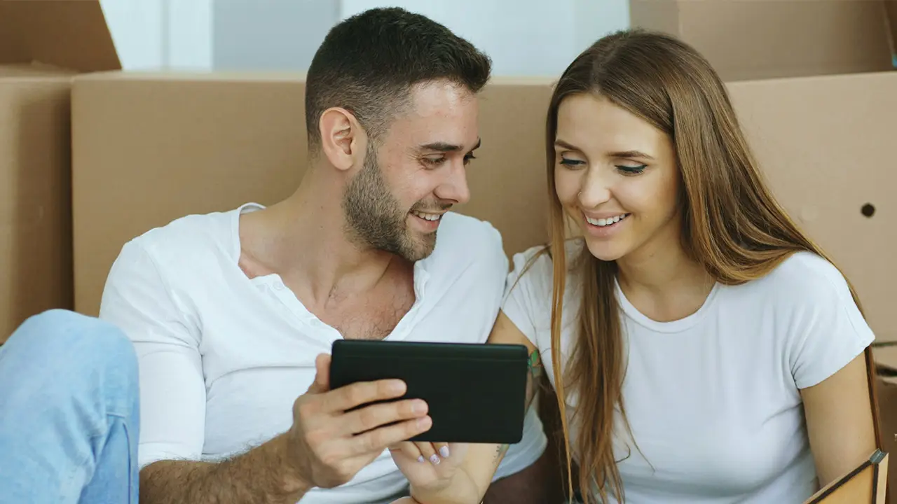 An image of a tenant couple searching online for Toronto rentals on their phone reading the description of the toronto rental listings.