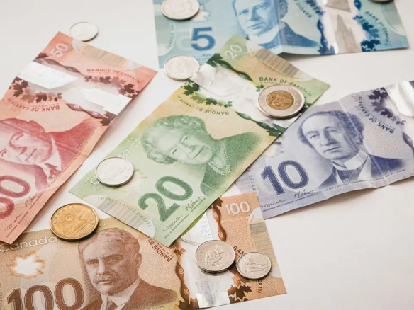 An image of Canadian money scattered on a white table.