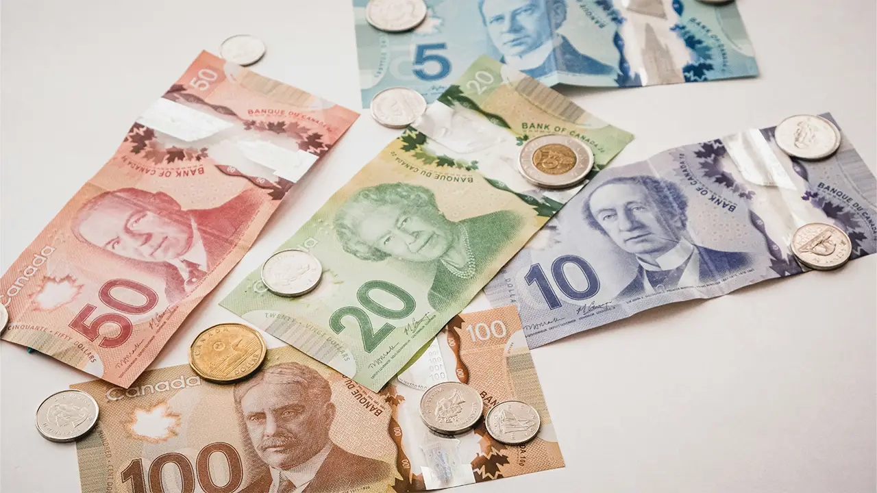 An image of Canadian money scattered on a white table.