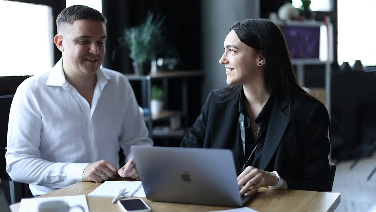 An image of a rental agent and property manager sitting side by side near a computer.